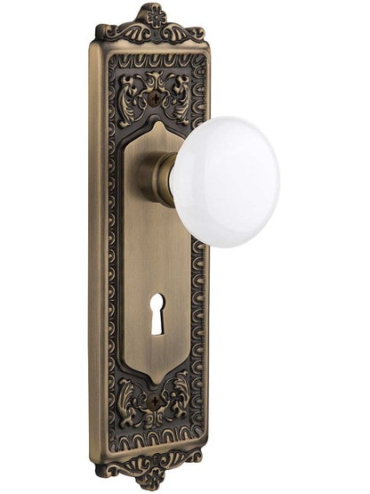 Egg and Dart Door Set with White Porcelain Knobs and Keyhole Single Dummy in Antique Brass.